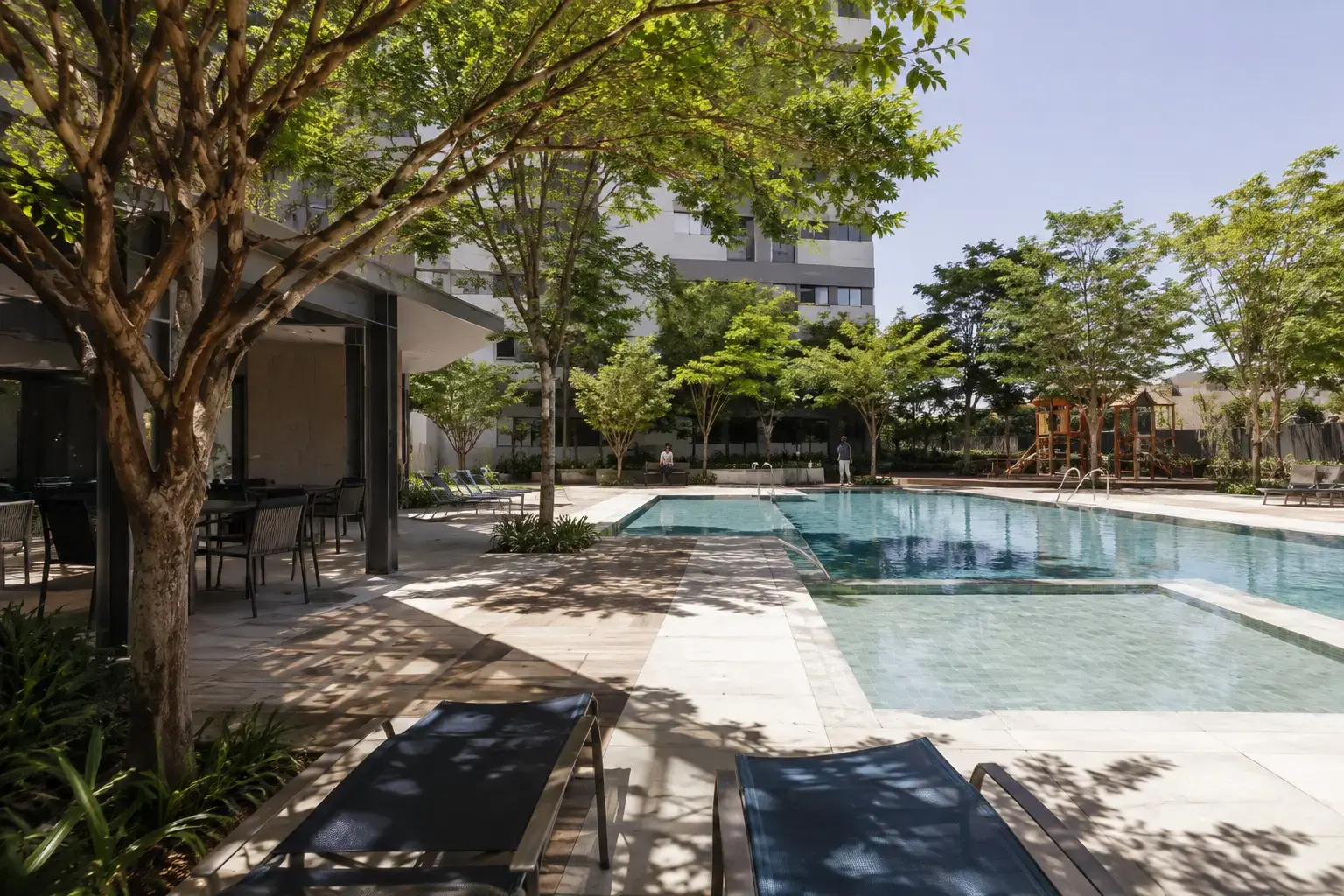 Piscina e área de lazer do Parque das Oliveiras em dia de sol
