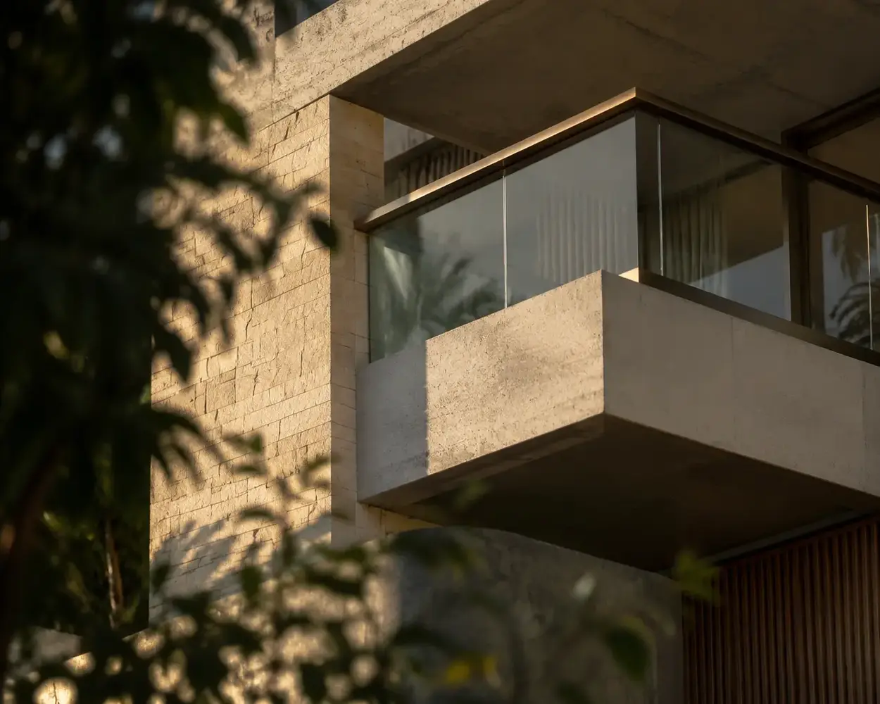 Detalhe de fachada em concreto, vidro e pedra de edifício residencial